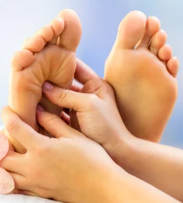 Hands of a reflexologist, carefully performing therapeutic reflexology techniques on a client's feet, highlighting the hands-on approach of the practice.