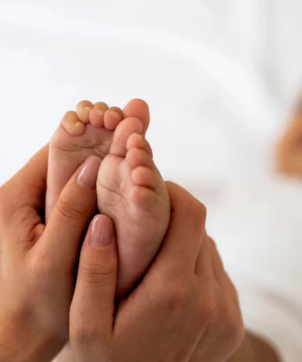 Hands of a reflexologist, carefully performing therapeutic reflexology techniques on a client's feet, highlighting the hands-on approach of the practice.