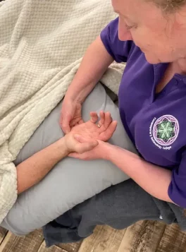 Jane Ford skillfully performing reflexology on a client's hands, demonstrating her expertise in applying this healing technique beyond the feet.